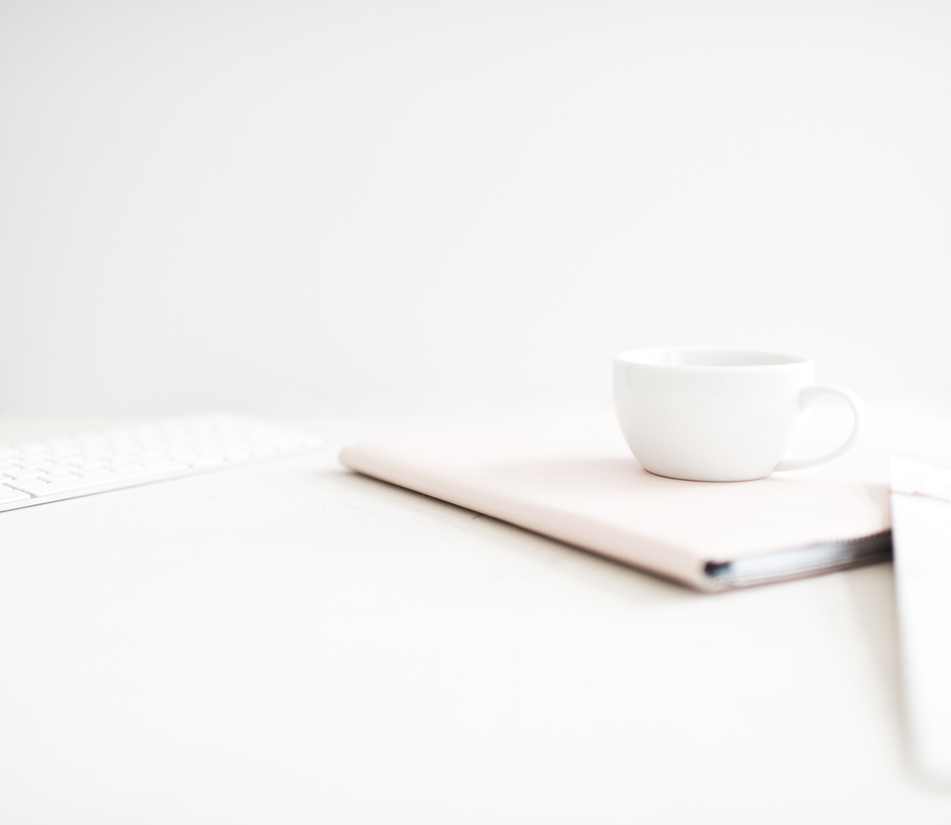 Tea Cup and a Notebook on a White Surface
